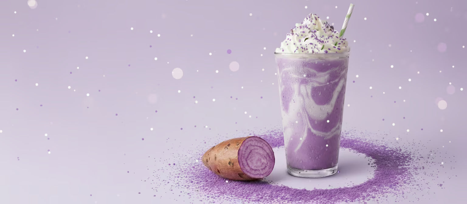 Creamy purple ube latte with whipped cream and fresh ube root on purple background with sparkles - UbePure natural ube powder