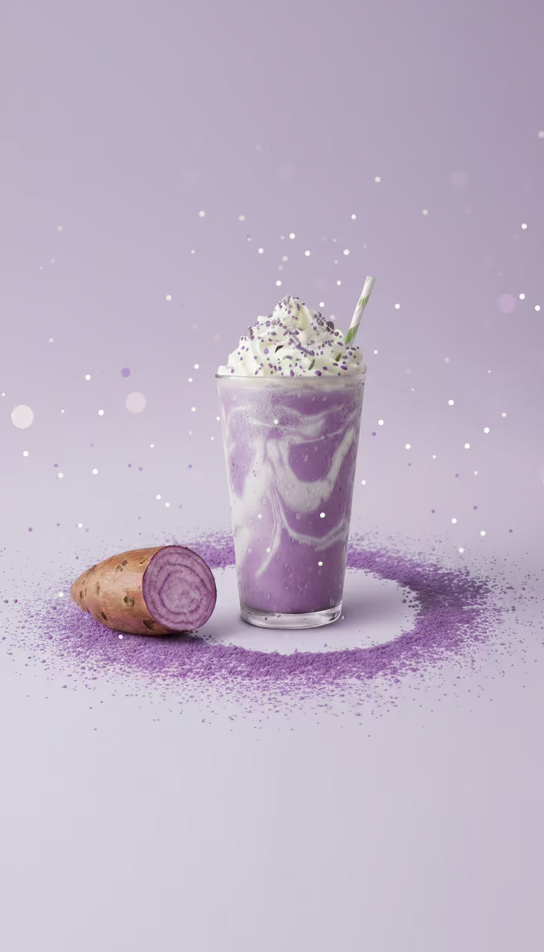 Creamy purple ube latte with whipped cream and fresh ube root on purple background with sparkles - UbePure natural ube powder